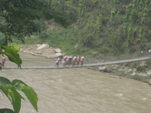 people with rice crossing bridge